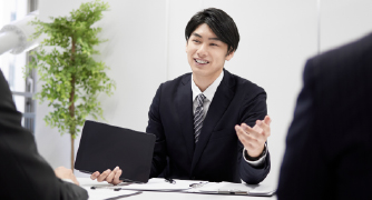 画像:スーツをきた男性が描いでお話している様子